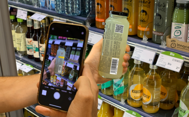 Mann liest mit einem Smartphone eine Flasche Jake's Lemonade aus