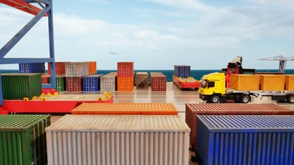 Containerhafen am helllichten Tag mit beladenem Lkw im Fokus 