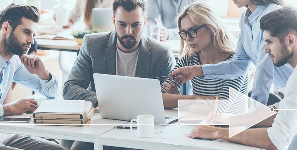 Eine Gruppe Personen schaut zusammen auf einen Laptop