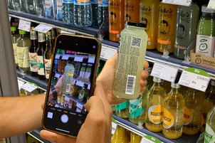 Scan eines 2D-Codes auf einer Jake's Lemonade Flasche am Kühlregal mit einem Smartphone