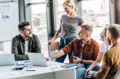 Eine Gruppe von jungen Leuten unterhalten sich im Büro